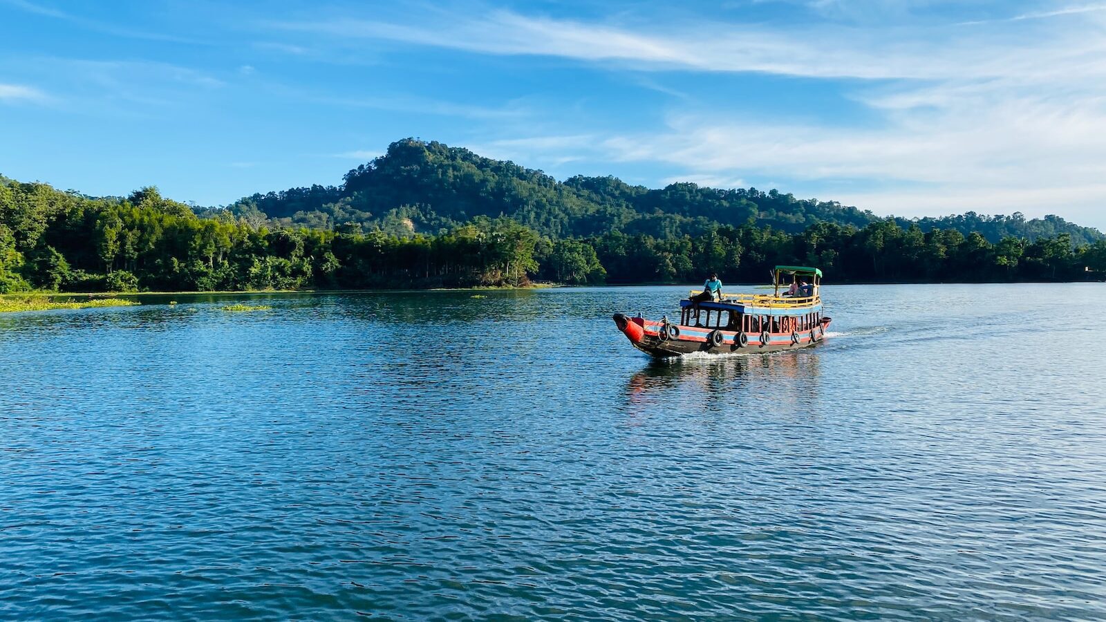 Rangamati a boat on a lake with a mountain in the background